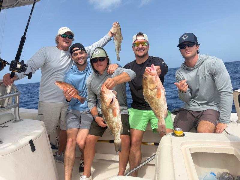 A group with their grouper and snapper aboard the Dreamgirl
