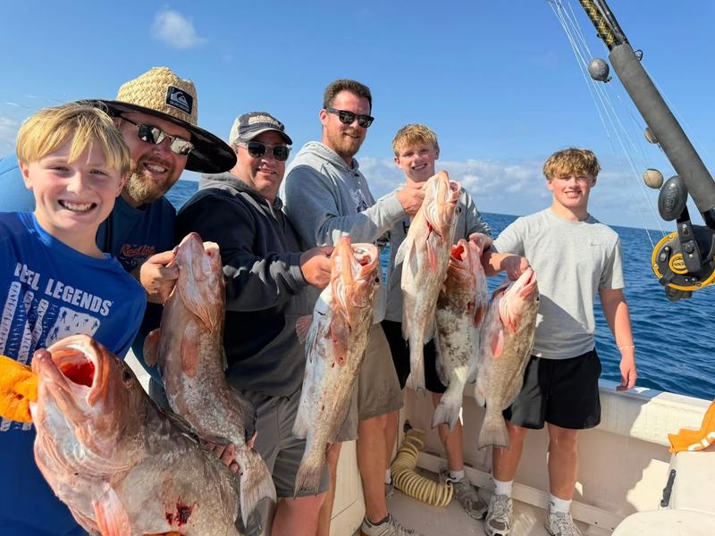 A family with a cooler full of grouper and snapper